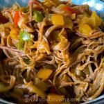 Carne mechada venezolana jugosa y desmechada con pimentón de colores, servida en un bowl