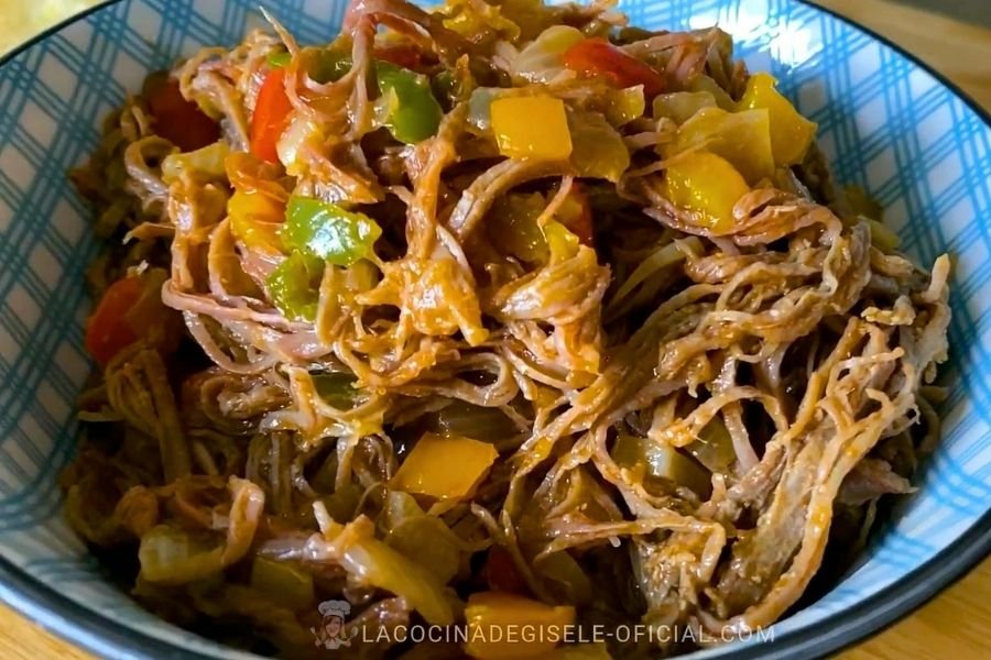 Carne mechada venezolana jugosa y desmechada con pimentón de colores en un bol